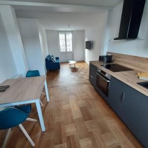 a kitchen with a table and a table and chairs at Appartemement F2 refait à neuf hyper centre in Coutances