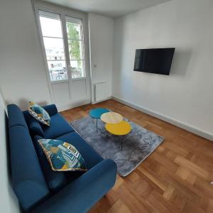 a living room with a blue couch and a table at Appartemement F2 refait à neuf hyper centre in Coutances