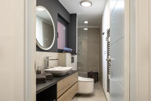 ein Badezimmer mit Waschbecken, Toilette und Spiegel in der Unterkunft Villa Infinity - Luxurious seaview Villa with enchanting Pool in Kali