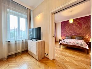 a bedroom with a bed and a flat screen tv at Exclusive Colourful Flat in the city in Budapest