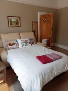 a bedroom with a white bed and a couch at Private rooms with breakfast in Bishop Auckland in Bishop Auckland