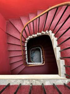 a spiral staircase in a building with a red wall at The Valentine - Townhouse Hotel in Edinburgh