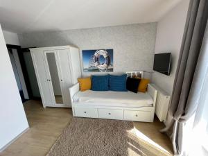 a small room with a white couch with blue pillows at Arenaapartments in Gdańsk