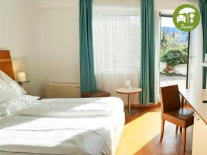 1 dormitorio con cama, mesa y ventana en arte Hotel Wien Stadthalle en Viena