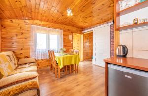 a dining room with a table and a kitchen at Uroczy Zakatek in Chłopy