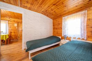 a bedroom with two beds in a log cabin at Uroczy Zakatek in Chłopy