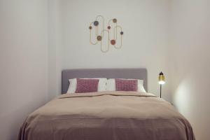 ein Schlafzimmer mit einem großen Bett mit lila Kissen in der Unterkunft The 77 ALMA in Wien