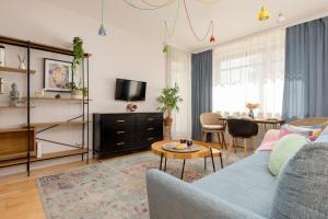 sala de estar con sofá azul y mesa en Wincentego Park Apartment by Renters en Varsovia