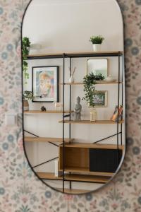 un espejo reflejo de un estante con plantas y cuadros en Wincentego Park Apartment by Renters en Varsovia