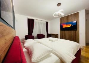 ein Schlafzimmer mit einem weißen Bett und einem roten Sofa in der Unterkunft Pitesti Residence in Piteşti