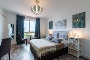1 dormitorio con 1 cama con lámpara de araña en Villa Cordouan en Saint-Palais-sur-Mer