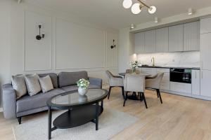 a living room with a couch and a table at Grano Residence Riverview - Pool, Gym & SPA by Downtown Apartments in Gdańsk