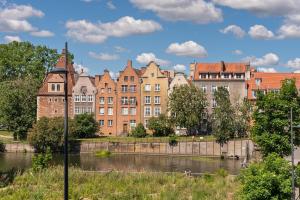 a group of buildings next to a river at Grano Residence Riverview - Pool, Gym & SPA by Downtown Apartments in Gdańsk
