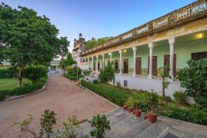 a courtyard of a building with potted plants at Neemrana's - Piramal Haveli in Bagar