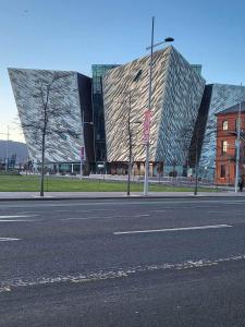 un gran edificio con una fachada de cristal junto a una calle en Ross Mill en Belfast