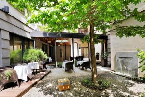 un restaurante con mesas, sillas y un árbol en Hotel Prokop Square, en Praga