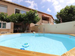a large blue swimming pool in front of a building at Beau 3 pièces climatisé, piscine privée, parking au Grau-du-Roi - FR-1-307-215 in Le Grau-du-Roi