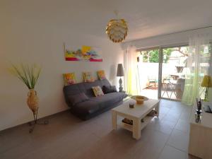 a living room with a couch and a table at Beau 3 pièces climatisé, piscine privée, parking au Grau-du-Roi - FR-1-307-215 in Le Grau-du-Roi +17 photos