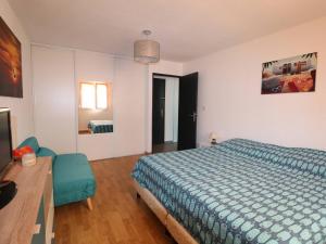 a bedroom with a bed and a television in it at Beau 3 pièces climatisé, piscine privée, parking au Grau-du-Roi - FR-1-307-215 in Le Grau-du-Roi