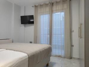 a bedroom with a bed and a window with a television at MAKexclusive in Leptokarya +35 photos