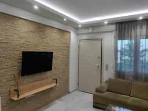 a living room with a television on a brick wall at MAKexclusive in Leptokarya