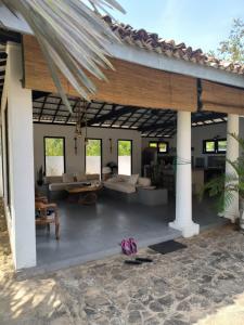 ein Wohnzimmer im Freien mit einer großen Holzpergola in der Unterkunft Beautiful Beachfront Villa - Lumi Villa in Tangalle