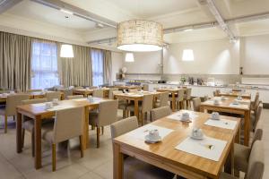 una sala da pranzo con tavoli e sedie in legno di Facón Del Mar Hotel a Mar del Plata