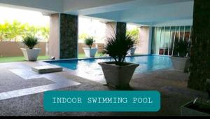 a swimming pool with a plant in a building at NH Studio Apartment Homestay in Wakaf Che Yeh