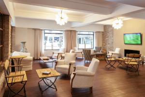 a living room with chairs and tables and windows at Facón Del Mar Hotel in Mar del Plata