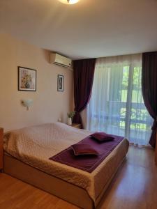 um quarto com uma cama e uma grande janela em Apartment Prestige Fort Beach, Studio em Sveti Vlas
