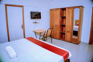 a bedroom with a bed and a table and a desk at DANA KIGALI HOTEL in Kigali