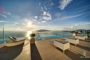 a patio with chairs and a pool with a view at Highsea Panorama Nha Trang Apartments in Nha Trang