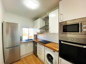 cocina con nevera de acero inoxidable y lavavajillas en Apartamento Céntrico-parking gratis Julio y Agosto-Wifi en Santander