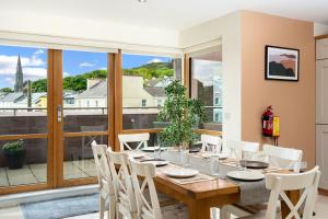a dining room with a table and chairs and a large window at Apartment 144 - Clifden in Clifden