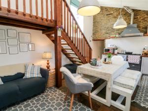 a living room with a table and a staircase at The Old Stables in Newquay