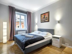 1 dormitorio con cama y ventana en Apartments Rynek Glowny, en Cracovia
