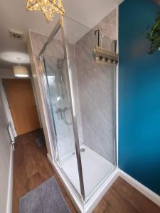 a shower with a glass door in a bathroom at Ross Mill in Belfast