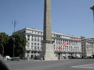 ローマにある3Houseの赤時計付きの建物前の高い碑