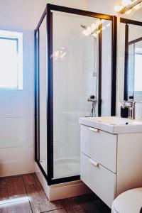 La salle de bains est pourvue d'une douche en verre et d'un lavabo. dans l'établissement Quinta da Bela Vista, à Lagos