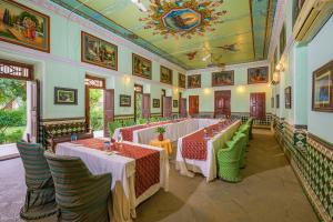 a restaurant with tables and chairs in a room at Neemrana's - Piramal Haveli in Bagar