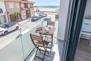 a balcony with a table and chairs and a view of the beach at Beach & Sea Guesthouse in Espinho
