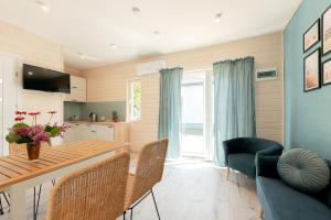 a kitchen and living room with a table and chairs at MIELENKO BEACH - domki in Mielenko