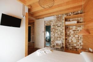 a bedroom with a bed and a brick wall at B&B Sant Pol - Adults Only in San Pol de Mar