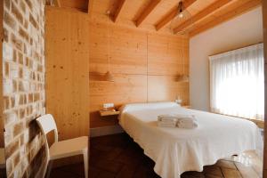 a bedroom with a white bed in a wooden wall at B&B Sant Pol - Adults Only in San Pol de Mar