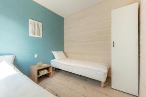 a room with two beds and a door to a bedroom at MIELENKO BEACH - domki in Mielenko