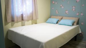 a bed in a bedroom with two blue pillows on it at Camping Miramar in Miami Platja