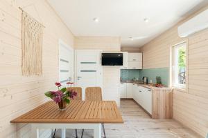 a kitchen with a wooden table with a vase of flowers at MIELENKO BEACH - domki in Mielenko