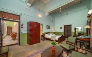 a bedroom with a bed and a living room at Neemrana's - Piramal Haveli in Bagar