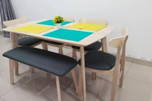 een houten tafel met vier stoelen en een tafel met een plant bij 77 Mantin # U Homestay - 4Bed & 4Bath in Mantin
