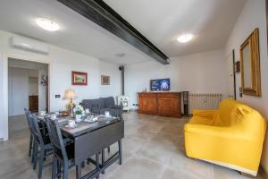 - un salon avec une table et un canapé jaune dans l'établissement Villa Teresa Apt Lake Garda View - Happy Rentals, à Soiano del Lago